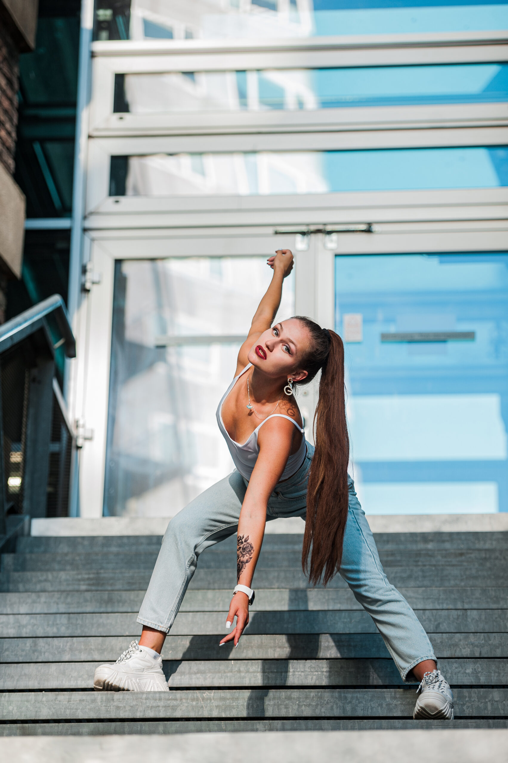 Emiliya Fernandez steht auf Metalltreppe